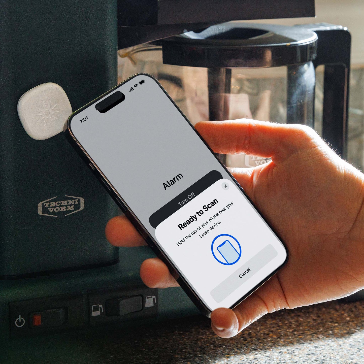 Scanning the Lasso Alarm Clock device next to a coffee pot in the kitchen